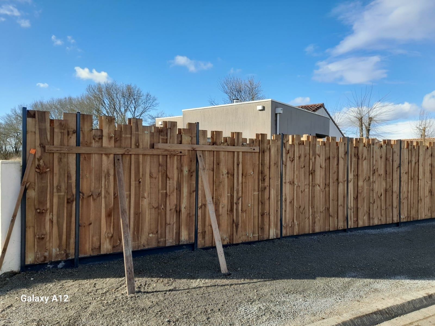 Clôture en bois à hauteurs variables avec poteaux aluminium, pour un rendu à la fois moderne et naturel